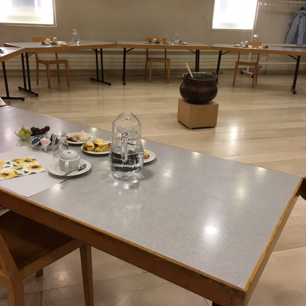 Tische im Kreis gestellt, eine Person pro Tisch, jede ihr Zvieri auf kleinen Tellerchen